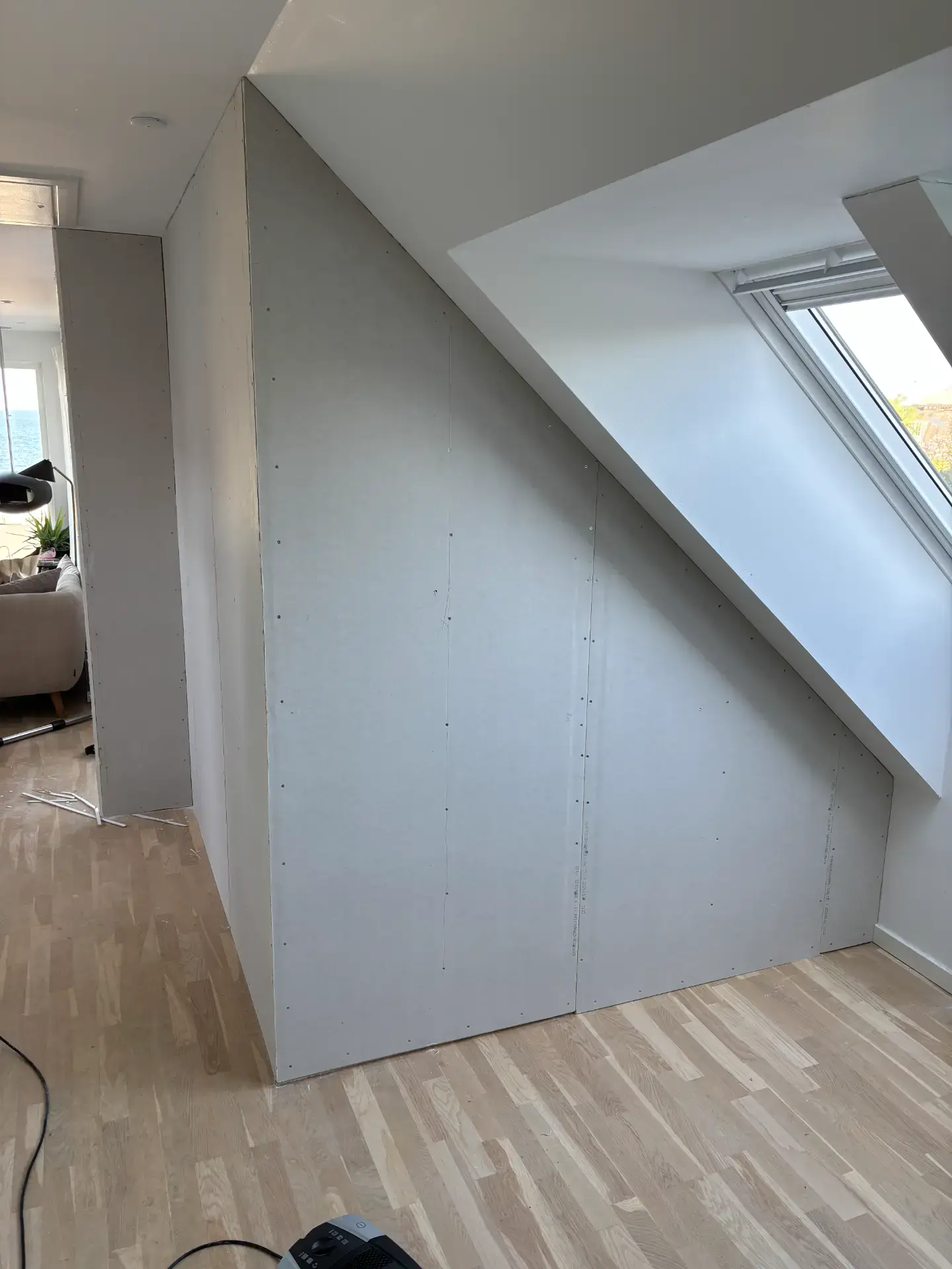 Loftsvindue installeret under skrå væg i et moderne hjem.